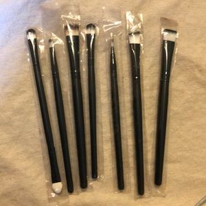 Bundle of unused makeup brushes and mascara tube